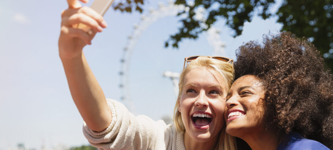 deux amies prenant un selfie avec une grande roue en arrière-plan