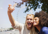 deux amies prenant un selfie avec une grande roue en arrière-plan