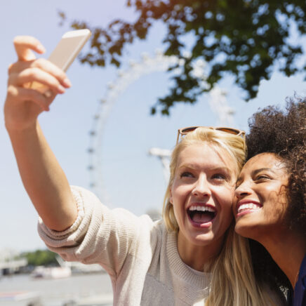deux amies prenant un selfie avec une grande roue en arrière-plan