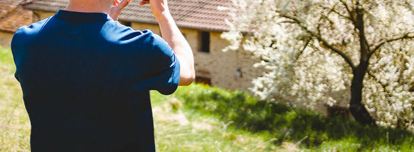 jeune homme prenant une photo d'une maison de campagne