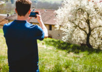 jeune homme prenant une photo d'une maison de campagne