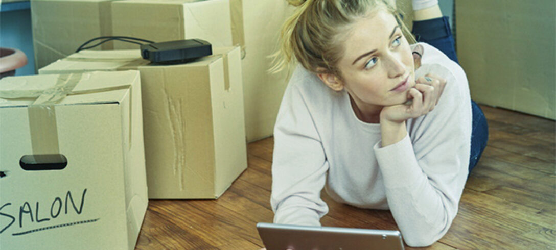femme allongée sur le ventre avec une tablette à la main, très attentionnée