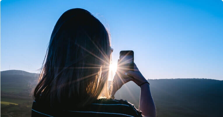 femme prenant une photo avec son téléphone portable du paysage