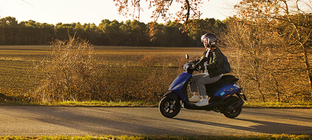 femme conduisant un scooter dans la campagne