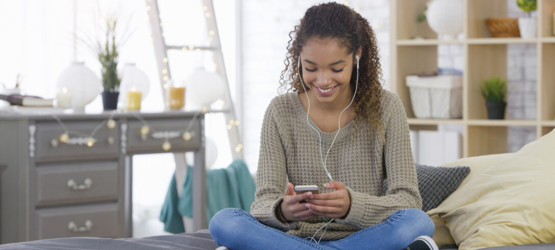 Une jeune fille au téléphone avec ses écouteurs