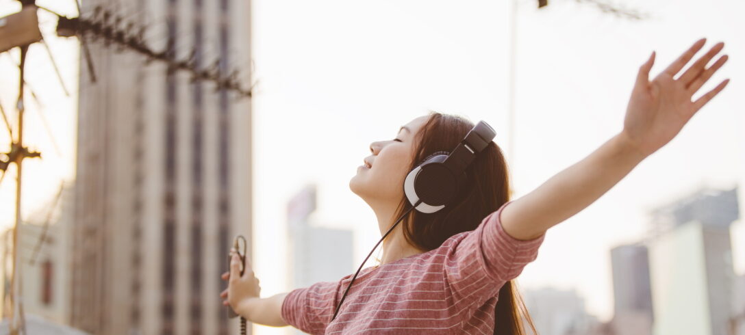 enfant écoutant de la musique les yeux fermés avec ses écouteurs dans la rue