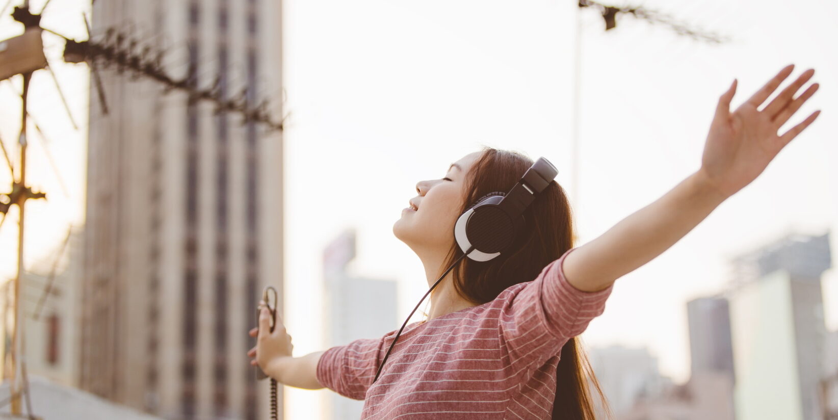 enfant écoutant de la musique les yeux fermés avec ses écouteurs dans la rue