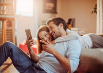 heureux couple d'amoureux regardant quelque chose sur leur téléphone portable
