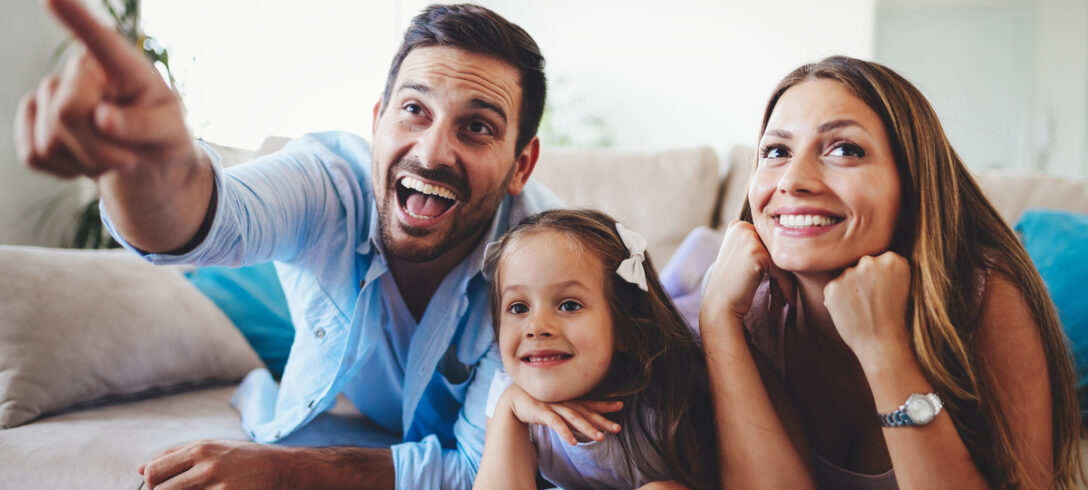 joyeuse famille allongée sur le canapé devant la télé