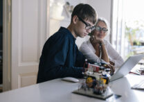 jeune ingénieur montrant ses inventions informatiques à sa grand-mère
