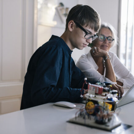 jeune ingénieur montrant ses inventions informatiques à sa grand-mère