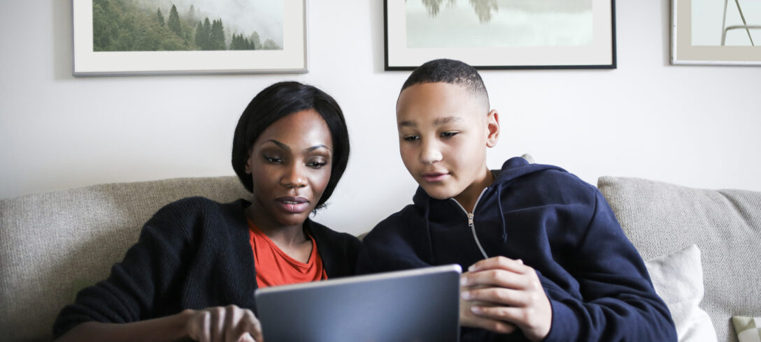 mère utilisant sa tablette pendant que son fils à côté d'elle regarde
