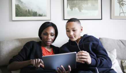 mère utilisant sa tablette pendant que son fils à côté d'elle regarde