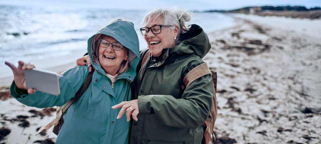 deux amies âgées prenant un selfie sur la plage