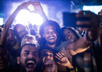 Grand groupe d'amis heureux s'amusant tout en prenant un selfie avec un téléphone portable lors d'un concert de musique.