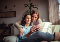 mère et fille s'embrassant en regardant une vidéo sur youtube