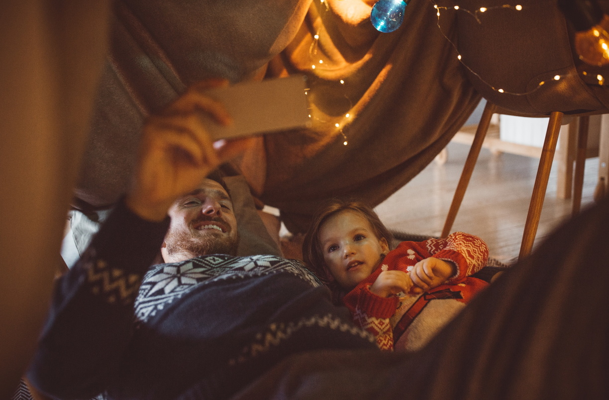 père et fille regardant un film sur un téléphone portable