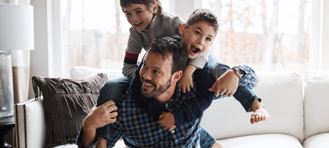 enfants sur le dos de leur père jouant