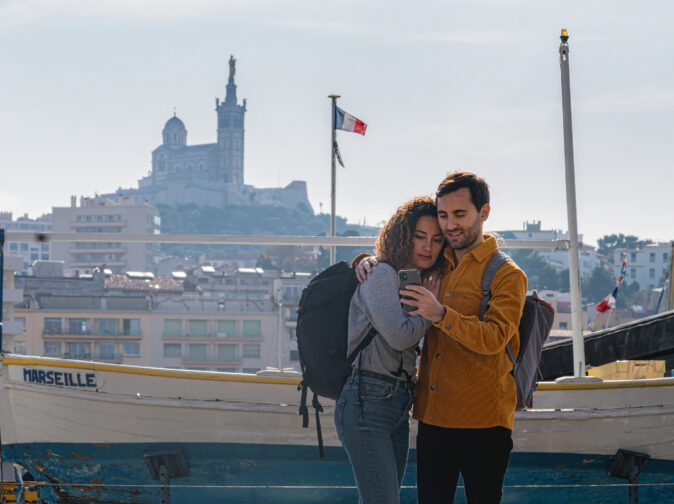 un couple de touristes à la recherche d'itinéraires sur leur téléphone portable