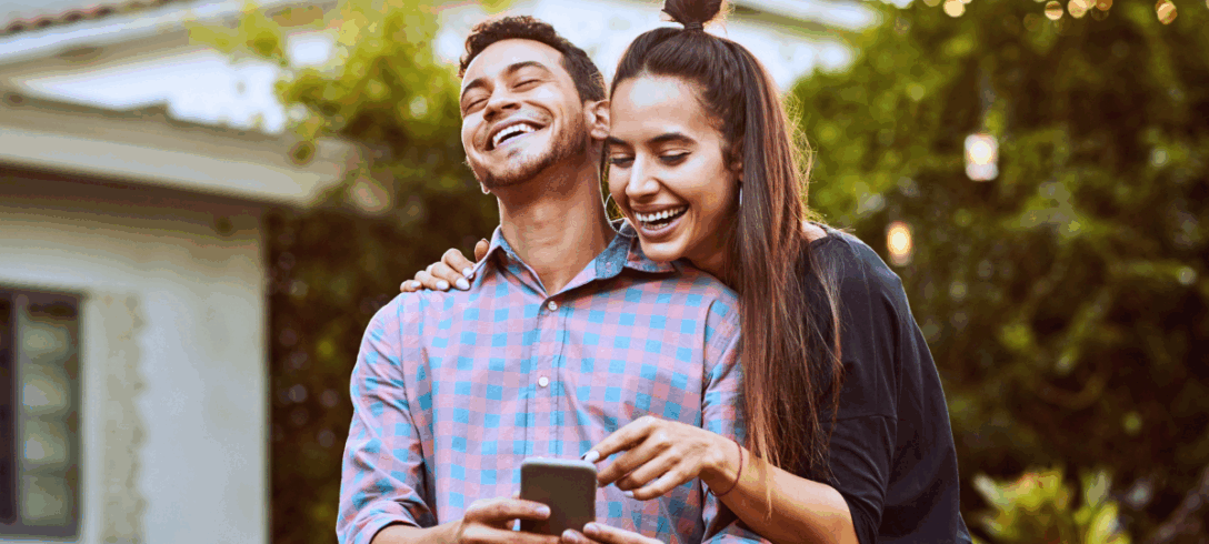 couple d'amoureux riant en regardant son téléphone portable