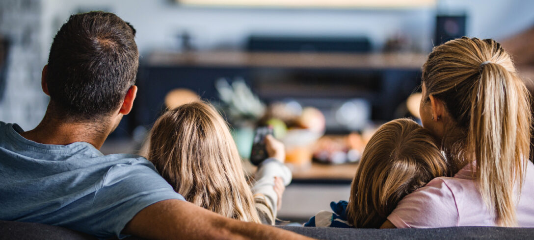 Famille assise sur un canapé en regardant la télévision