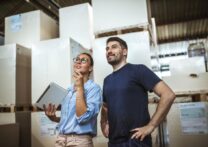 deux hommes d'affaires regardant des palettes dans un entrepôt