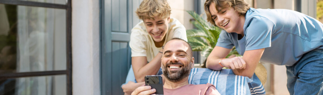 Un papa montre son téléphone à ses deux fils