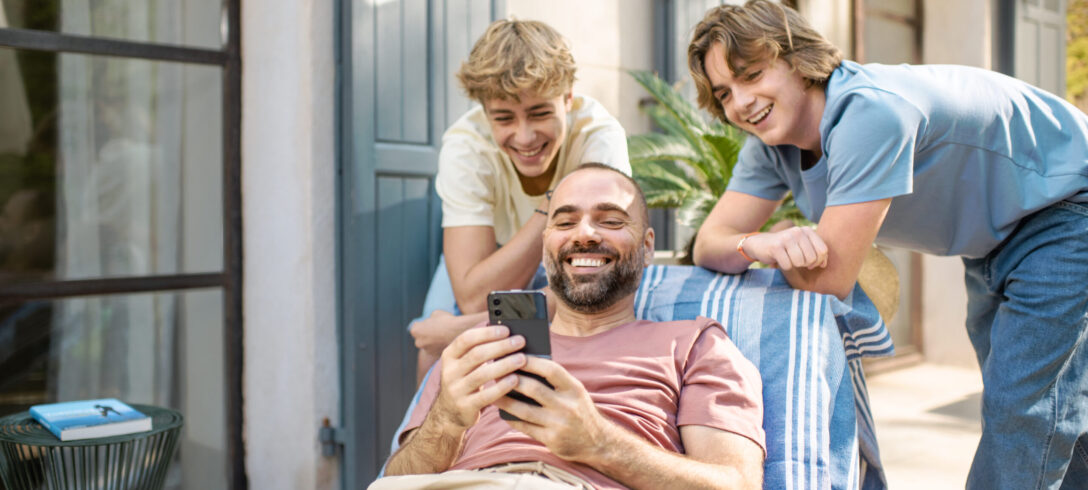 Un papa montre son téléphone à ses deux fils