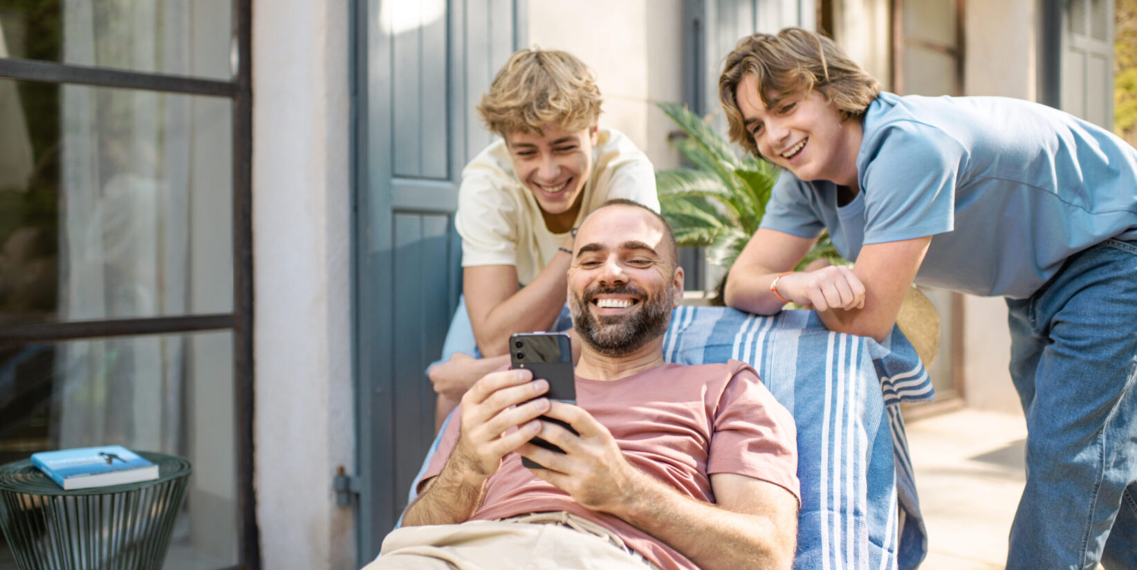 Un papa montre son téléphone à ses deux fils