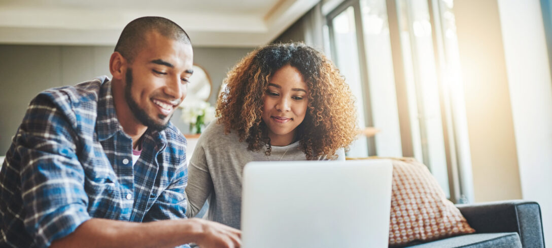 Photo d'un jeune couple utilisant un ordinateur portable tout en travaillant sur les finances de sa maison