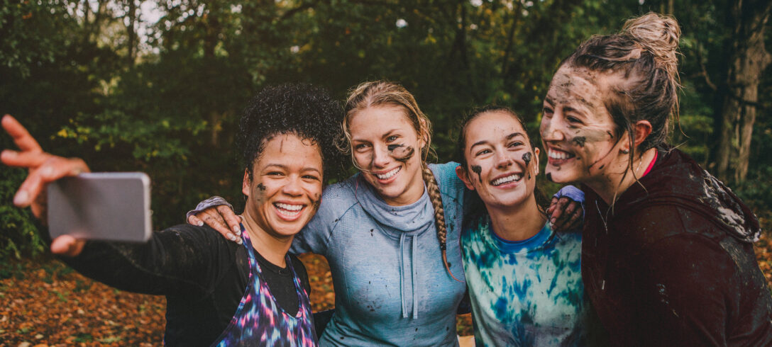 4 amis prenant un selfie après un test tous couverts de boue