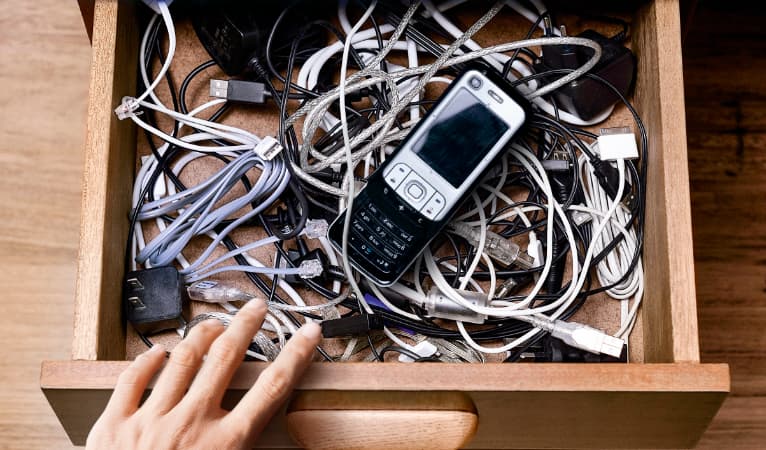 vieux téléphone portable plus câbles abandonnés dans un tiroir