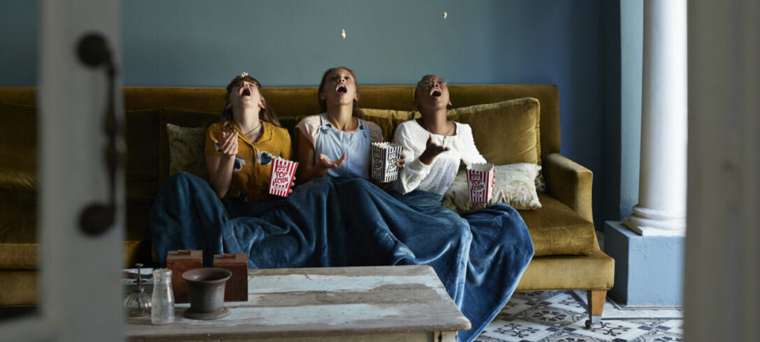 3 amis attrapant du pop-corn avec la bouche