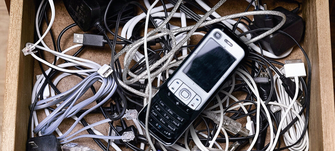 tiroir avec vieux téléphone portable et câbles