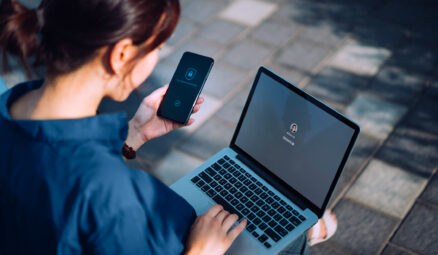 femme déverrouillant son ordinateur portable à l'aide de son téléphone portable