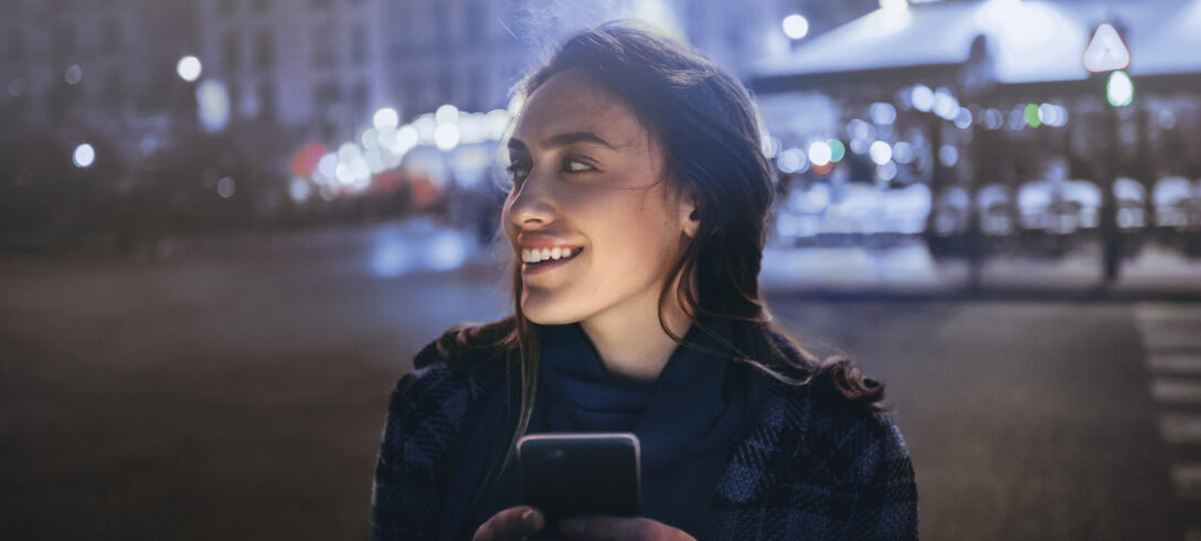 Femme textos au téléphone à Paris la nuit.