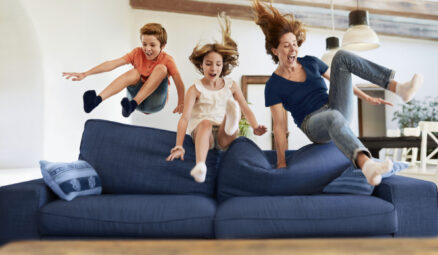 mère et deux enfants sautant sur le canapé