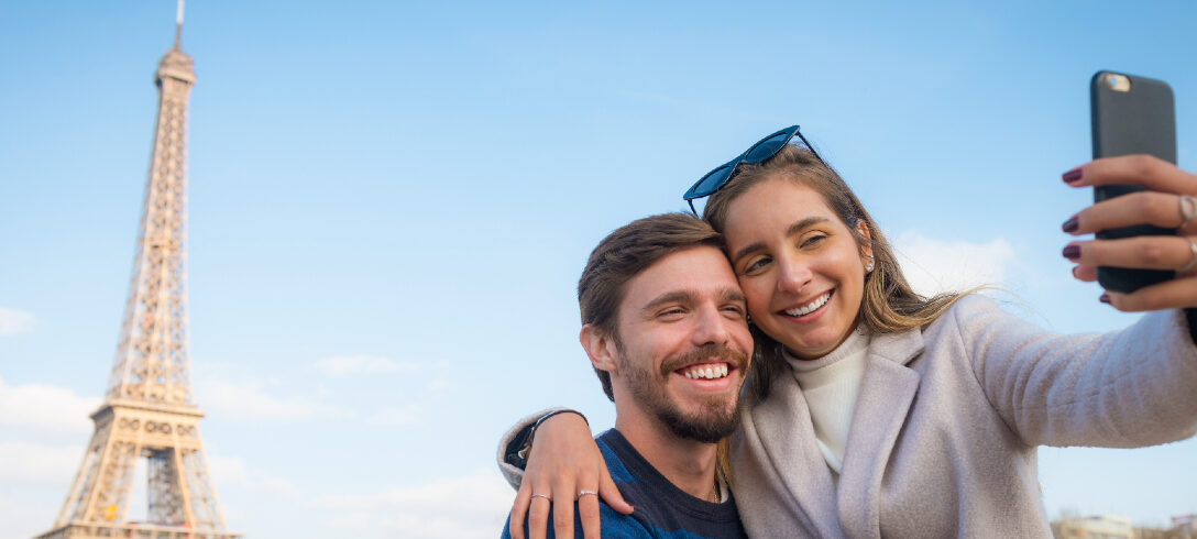 Un jeune couple visite Paris et prend des selfies devant les monuments de Paris