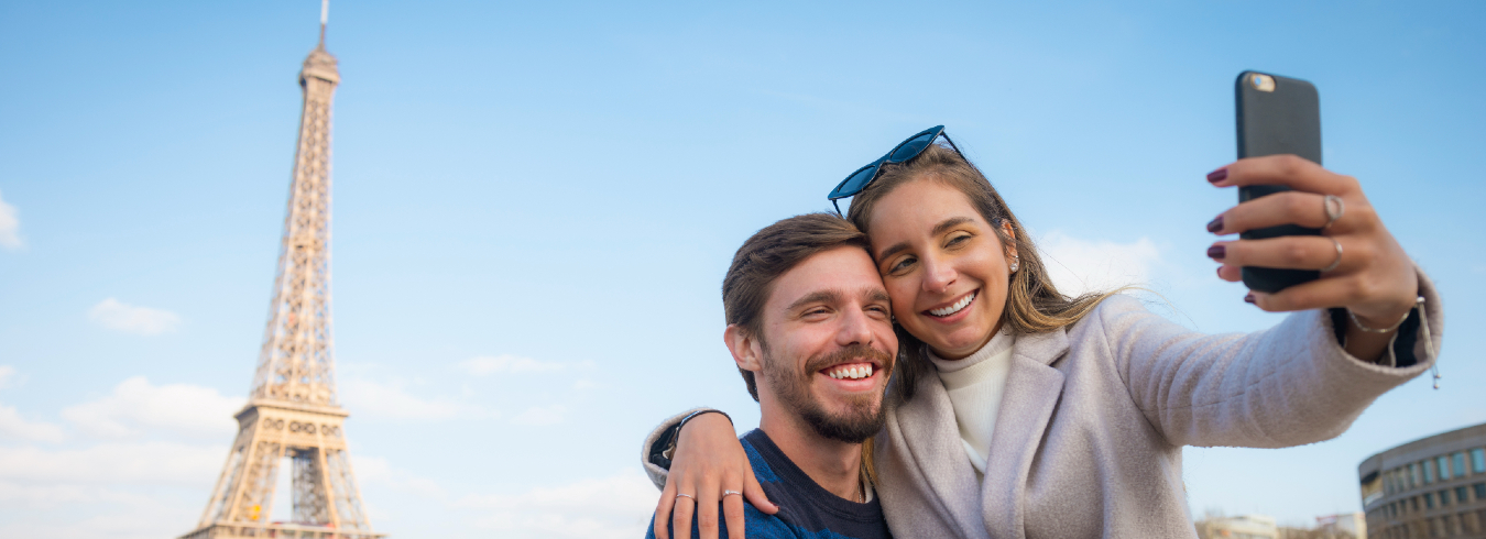 Un jeune couple visite Paris et prend des selfies devant les monuments de Paris