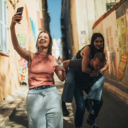 jeune homme prenant un selfie avec ses deux amis dans une rue de ville en france