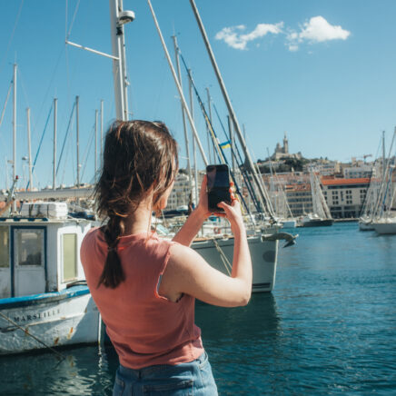 jeune homme prenant une photo de bateaux à la marina