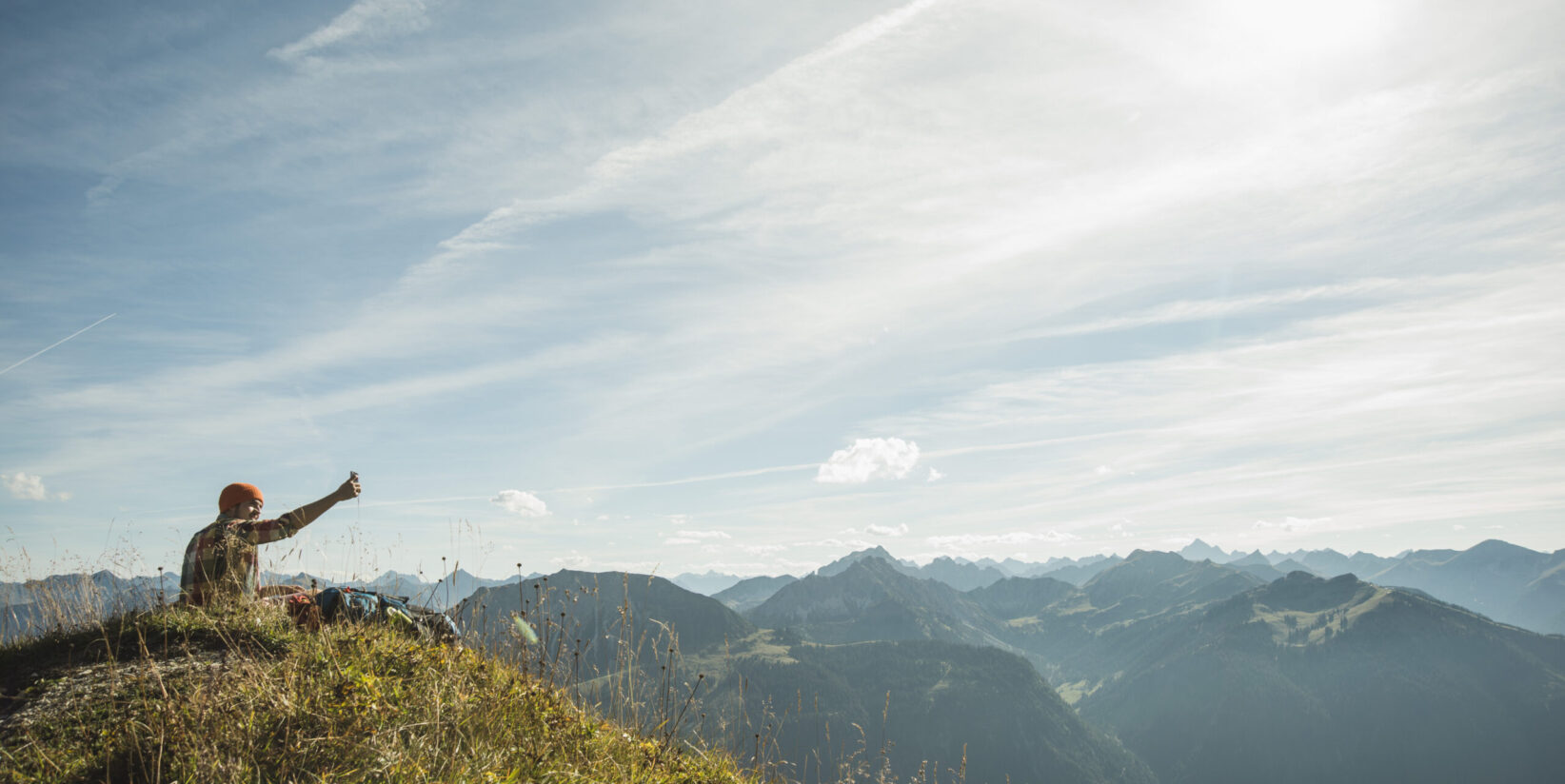 Autriche, Tyrol, Tannheimer Tal, jeune homme prenant en selfies mountainscape