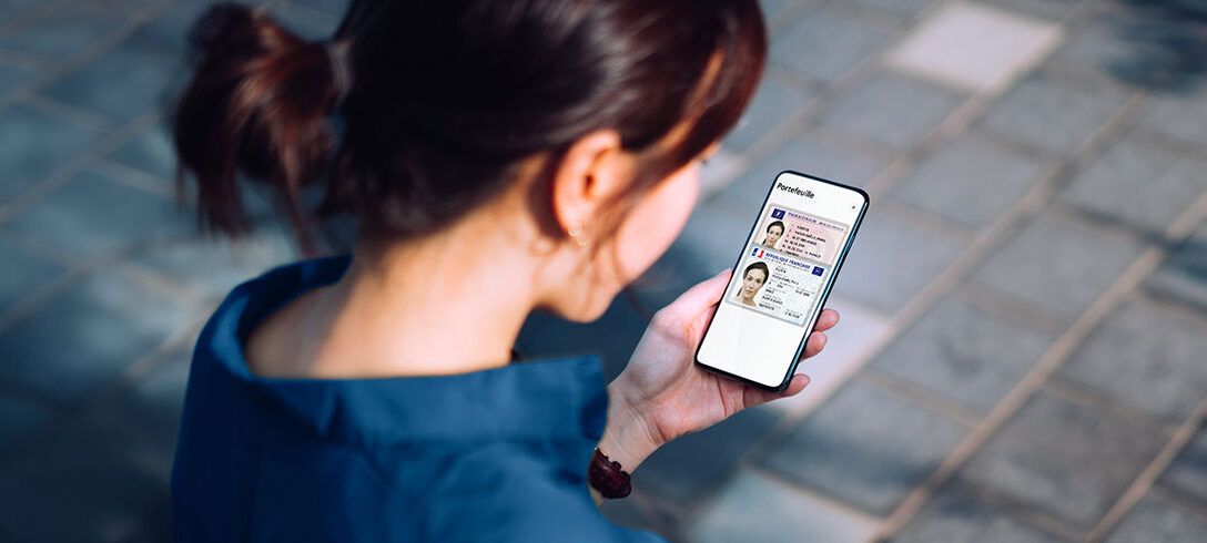 Femme utilisant son téléphone pour son portefeuille numérique avec une carte d'identité et son permis