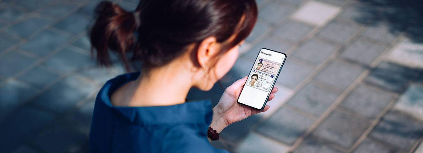 Femme utilisant son téléphone pour son portefeuille numérique avec une carte d'identité et son permis
