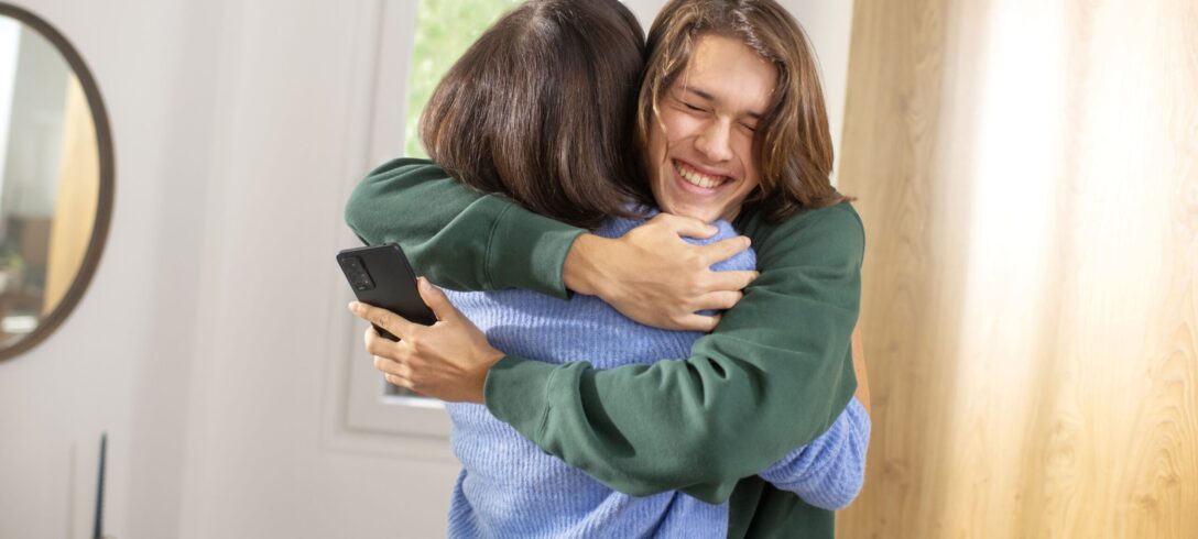 Ado qui prend sa maman dans les bras car il a reçu son premier téléphone