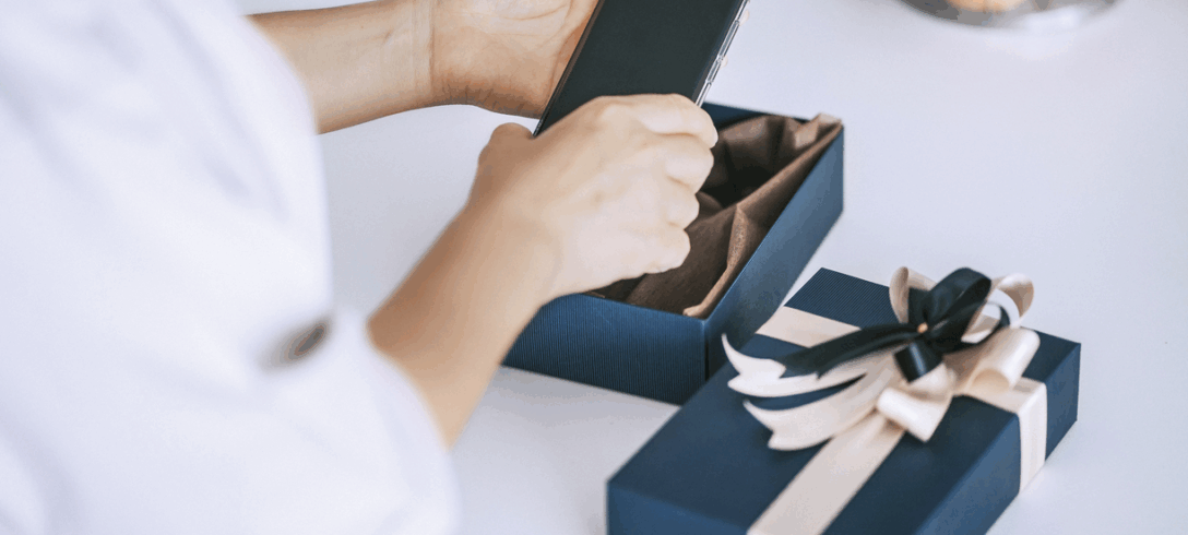 femme sortant un smartphone d'une boîte cadeau