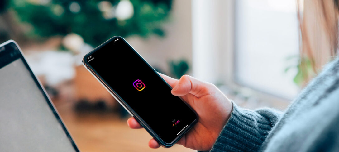 femme tenant dans sa main un téléphone avec logo Instagram sur l'écran