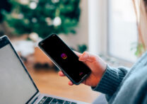 femme tenant dans sa main un téléphone avec logo Instagram sur l'écran